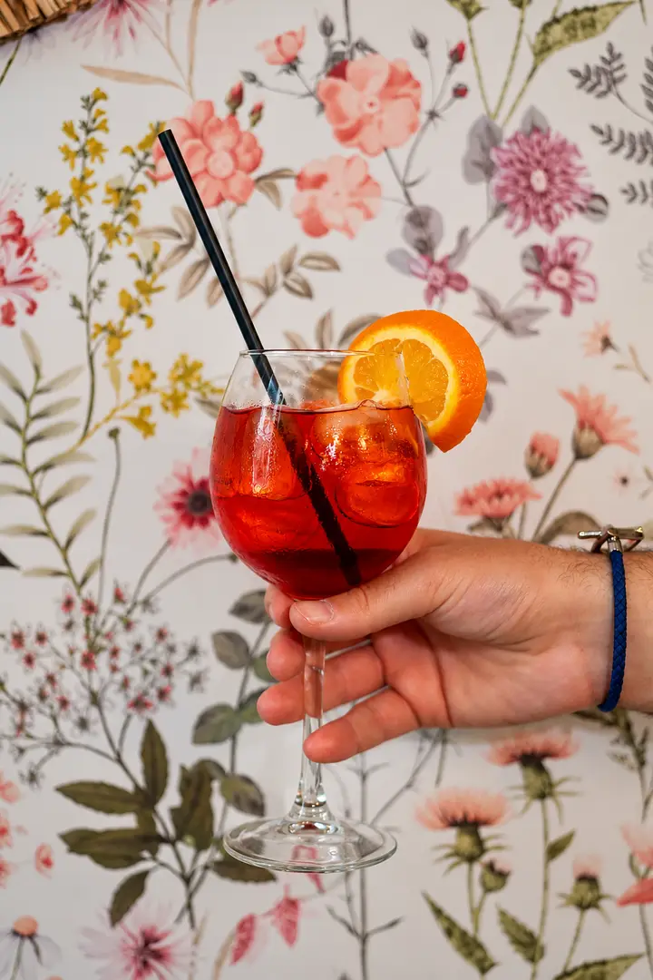 A spritz held up against the floral wallpaper